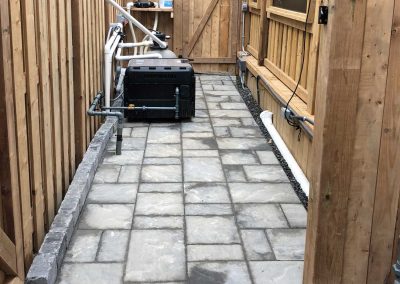 Interlocking stone pathway in a residential backyard entrance